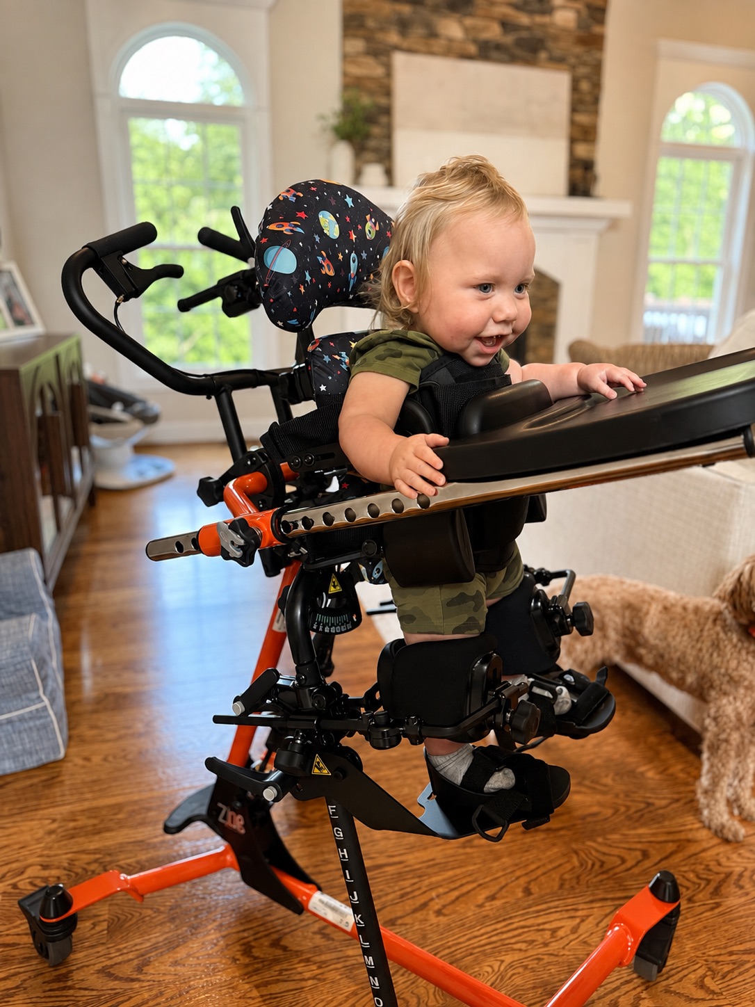Oliver smiling while standing in his adaptive stander